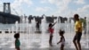 ARCHIVO - La gente se refresca en una fuente de agua en Domino Park mientras una ola de calor azota la región en Brooklyn, Nueva York, EEUU, el 8 de agosto de 2022.