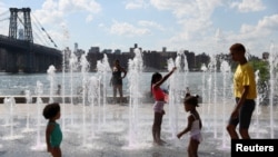 ARCHIVO - La gente se refresca en una fuente de agua en Domino Park mientras una ola de calor azota la región en Brooklyn, Nueva York, EEUU, el 8 de agosto de 2022.