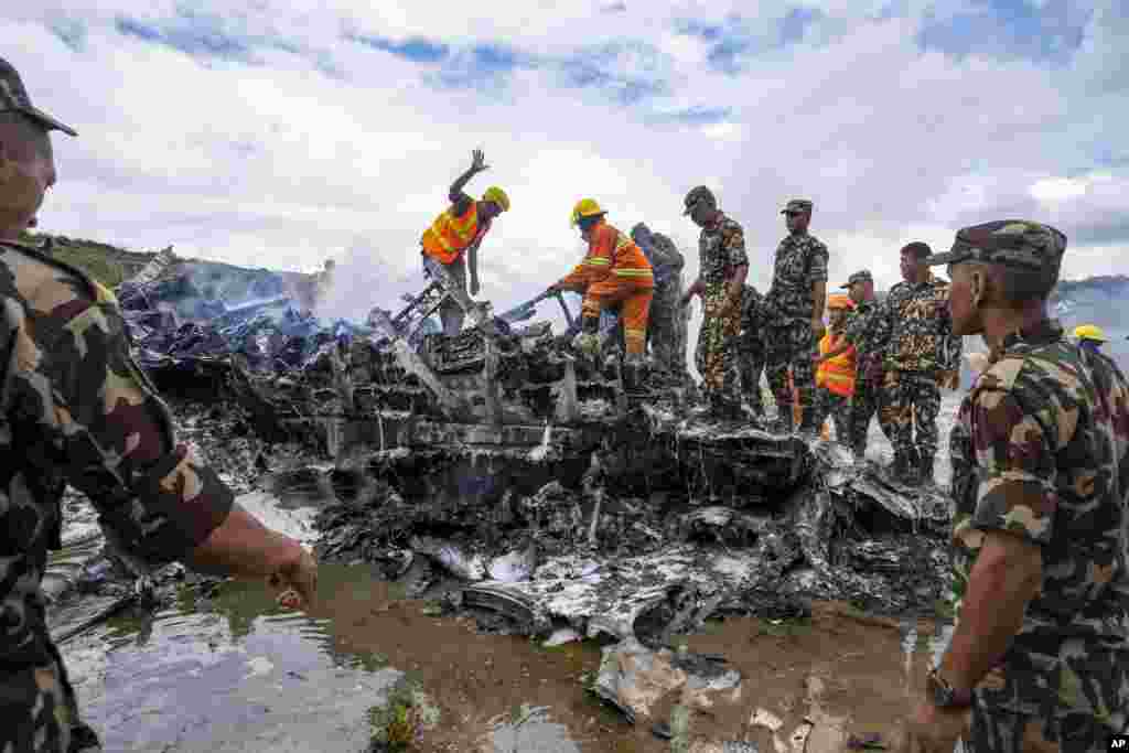 Nepal army personnel sort through the debris after a domestic plane belonging to Saurya Airlines crashed just after taking off at Tribhuvan International Airport in Kathmandu.