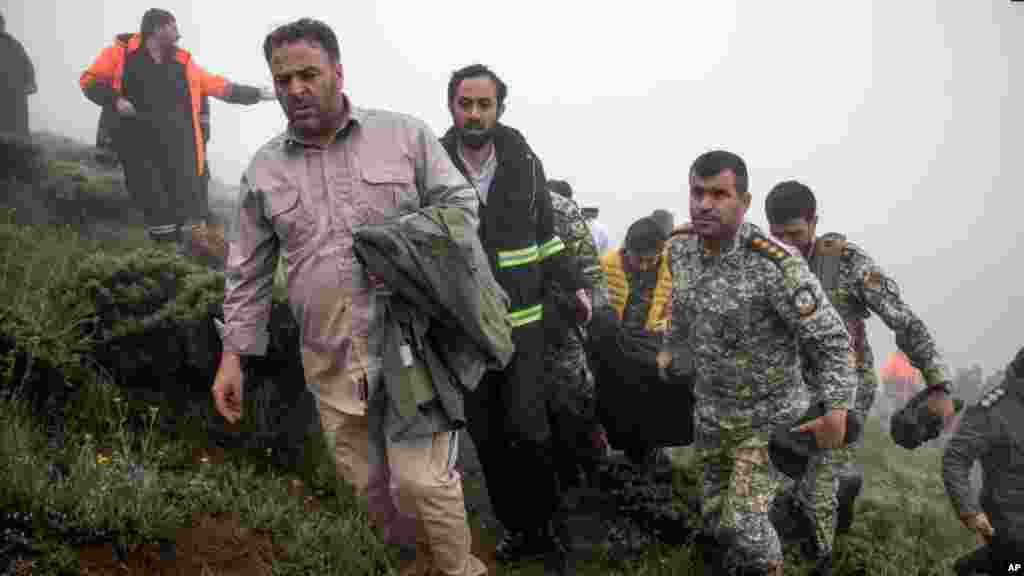 En esta fotografía proporcionada por la agencia de noticias Moj, miembros del equipo de rescate cargan el cuerpo de una víctima después de que un helicóptero que transportaba al presidente iraní Ebrahim Raisi se estrellara en Varzaghan, en el noroeste de Irán, el 20 de mayo de 2024.