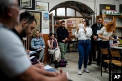 FILE - Volunteers look at an election representative showing a ballot during tabulation at a polling station in Istanbul, Turkey, May 28, 2023. Turks will head to the polls March 31, 2024, to elect mayors and local administrators.