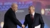 FILE - Russian President Vladimir Putin shakes hands with moderator Dimitri Simes during a session of the St. Petersburg International Economic Forum in St. Petersburg, Russia, June 16, 2023. Simes' Virginia home was the target of a recent FBI raid.