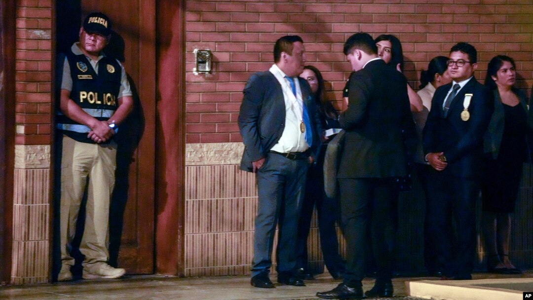 Police and prosecutors stand outside President Dina Boluarte's home during a raid aimed at seizing luxury watches as part of a preliminary investigation into allegations of illicit enrichment, in Lima, Peru, March 30, 2024. 