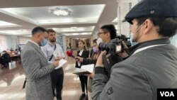 FILE - On a presidential election day, OSCE/ODIHR observer mission members talk with Uzbek journalists at a voting center in Tashkent, Uzbekistan, Oct. 24, 2021. (VOA)
