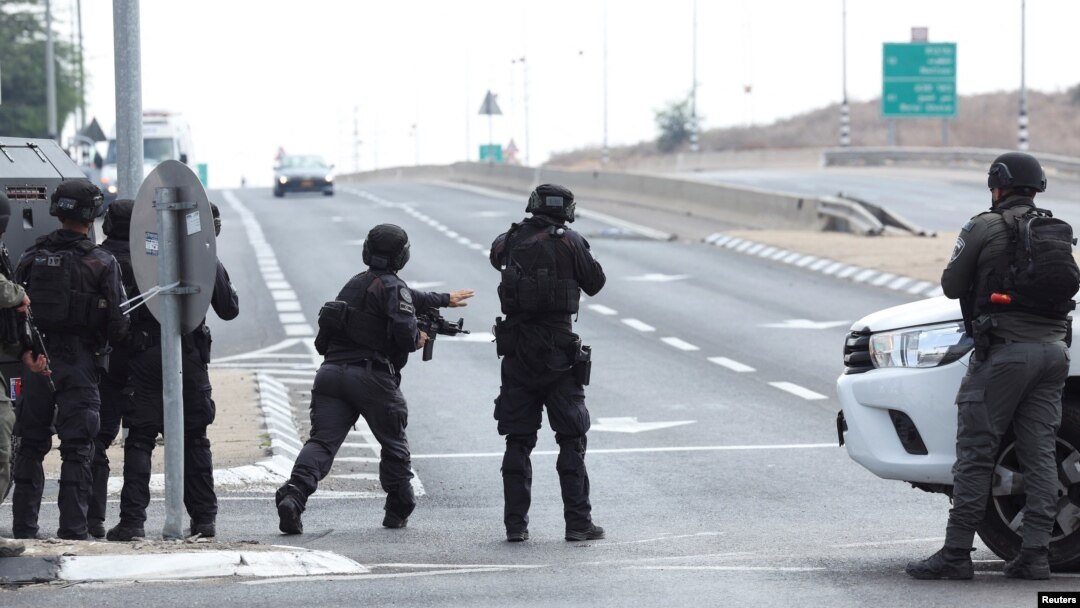 Pasukan Israel mengambil posisi ketika sebuah mobil mendekat di jalan menyusul infiltrasi massal oleh kelompok bersenjata Hamas dari Jalur Gaza, dekat Sderot di Israel selatan, 8 Oktober 2023. (Foto: REUTERS/Ronen Zvulun)