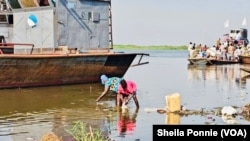 Un niño y una mujer lavan intestinos de un matadero en el río Nilo, en Bor, estado de Jonglei, Sudán del Sur.