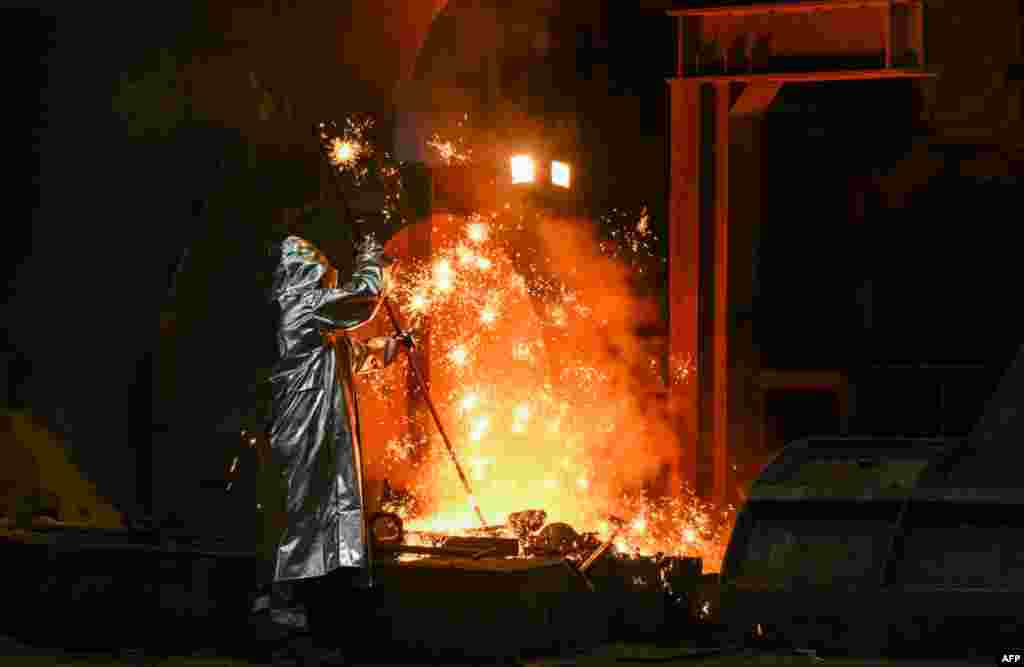 An employee takes a sample from a blast furnace 8 during the visit of the German president in Duisburg, western Germany.