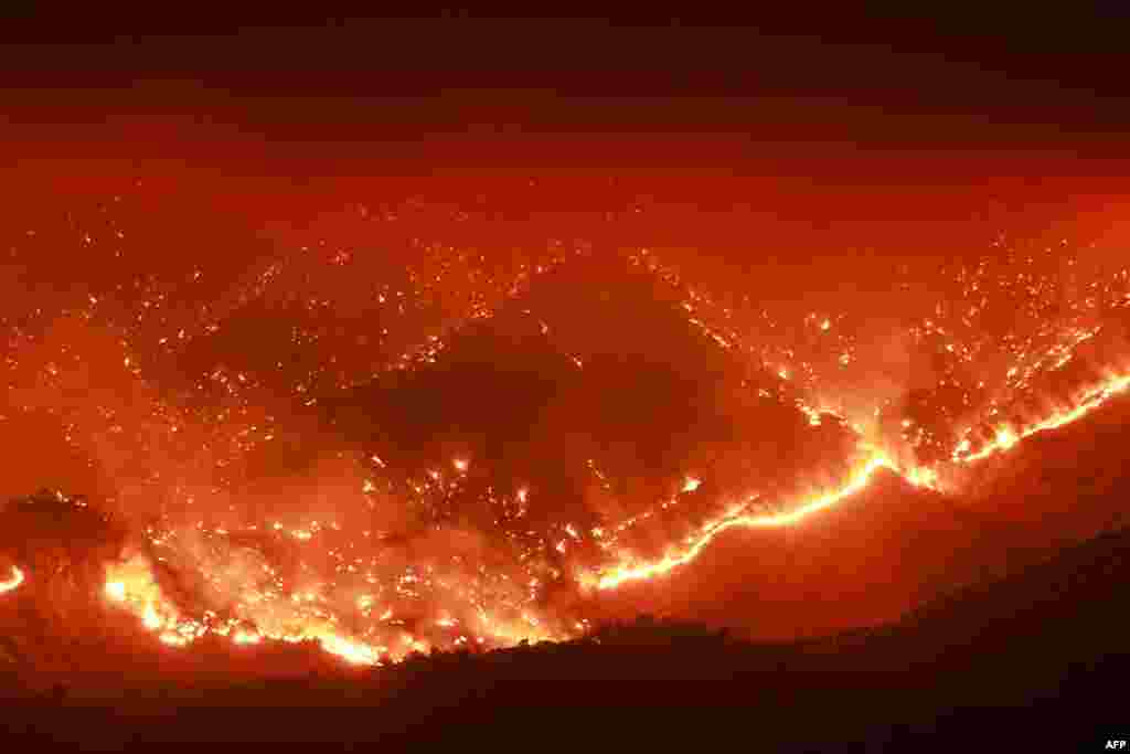 Embers glow at night as the Basin Fire burns in the Sierra National Forest in Fresno County, California, June 26, 2024.
