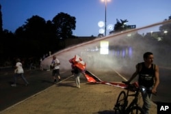 Police use water cannons to disperse demonstrators blocking a road during a protest against Israeli Prime Minister Benjamin Netanyahu's government and calling for the release of hostages held in Gaza by Hamas militants, in Jerusalem, May 20, 2024.