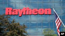 Bendera Amerika Serikat terpasang di depan fasilitas Sistem Pertahanan Terpadu milik perusahaan Raytheon yang berlokasi di Woburn, Massachusetts, pada 10 Juni 2019. (Foto: AP/Elise Amendola)