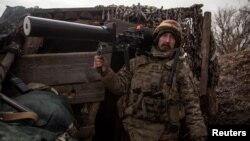 A Ukrainian service member holds an anti-drone rifle in a trench at a position outside the frontline town of Horlivka, amid Russia's attack on Ukraine, in Donetsk region, Ukraine, March 1, 2023. 