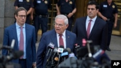 FILE - Former Senator Bob Menendez, center, speaks to reporters as he leaves federal court in New York, July 16, 2024.