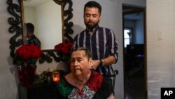 Joaquin Sanchez plays with the hair of his grandmother Aurora Sandoval at the family home Dec. 26, 2023, in Chicago.