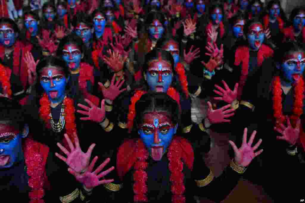 College students with faces painted in blue pose for the media at an event held ahead of Hindu festival Janmashtami in Mumbai, India, Sept. 4, 2023.