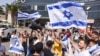 People wave Israeli flags as they celebrate after hostages who were kidnapped in a Hamas-led attack on Oct. 7. were rescued from Gaza Strip, at the Sheba Medical Center in Ramat Gan, Israel, June 8, 2024.
