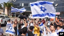 People wave Israeli flags as they celebrate after hostages who were kidnapped in a Hamas-led attack on Oct. 7. were rescued from Gaza Strip, at the Sheba Medical Center in Ramat Gan, Israel, June 8, 2024.