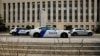 Police cars sit in front of the federal courthouse in Washington, where former president Donald Trump is expected to answer charges after a grand jury returned an indictment for efforts to overturn his 2020 election defeat, Aug. 2, 2023.