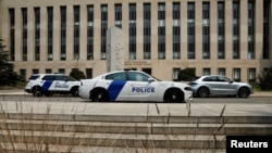 Police cars sit in front of the federal courthouse in Washington, where former president Donald Trump is expected to answer charges after a grand jury returned an indictment for efforts to overturn his 2020 election defeat, Aug. 2, 2023.
