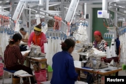FILE - Employees work at a factory supplier of the H&M brand in Kandal province, Cambodia, December 12, 2018.