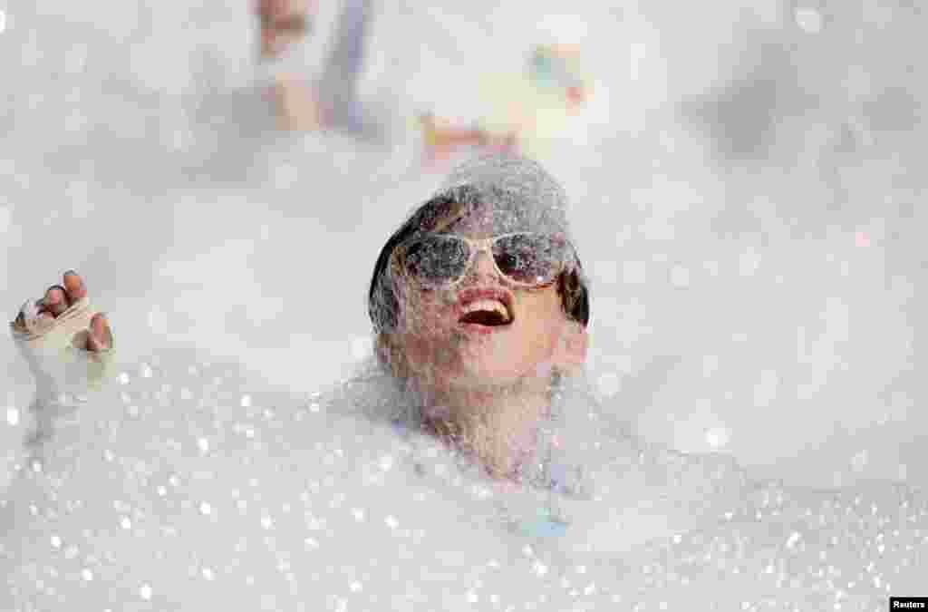 A participant runs through a foam bath during the &#39;Colour My Run&#39; charity fun run in Ta&#39; Xbiex, Malta.