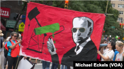 Эко-активисты во время марша несут плакат с изображением президента Байдена, 17 сентября 2023 г.