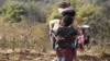 With an unemployed alcoholic husband at home, this tribal woman in Jharkhand, like most others, looks after her child while being the sole breadwinner in the family. (Arti Munda for VOA)