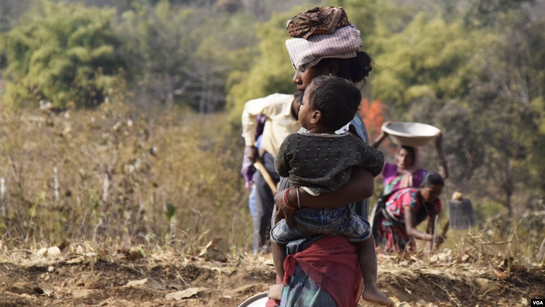 With an unemployed alcoholic husband at home, this tribal woman in Jharkhand, like most others, looks after her child while being the sole breadwinner in the family. (Arti Munda for VOA)