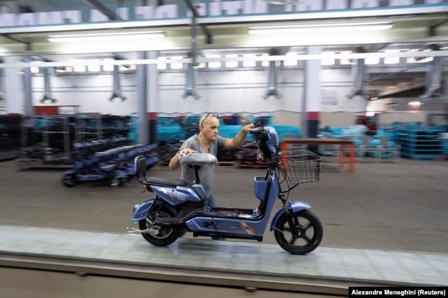 A worker pushes a scooter at the Caribbean Electric Vehicles (VEDCA) factory in Havana, Cuba, July 15, 2024. (REUTERS/Alexandre Meneghini)