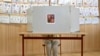 A woman prepares her ballots for the European Parliament elections at a polling station in Prague, Czech Republic, June 7, 2024.