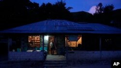 Bara Kilimandang stands at the door of his house whose electricity comes from solar energy, in Walatungga on Sumba Island, Indonesia, March 21, 2023.