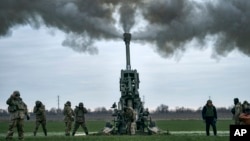 FILE - Ukrainian soldiers fire at Russian positions from a U.S.-supplied M777 howitzer in Ukraine's Kherson region, Jan. 9, 2023.