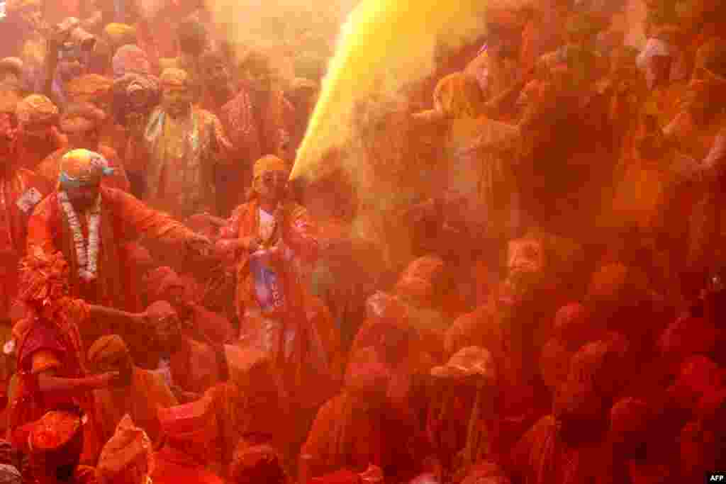 Devotees smear with colors as they celebrate Hindu spring festival of Holi at Shreeji temple in Barsana, Mathura district, India, Feb. 27, 2023. 