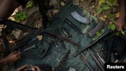 FILE - Members of Bamar People's Liberation Army (BPLA), who recently came back from a front line, clean their guns in territory belonging to the Karen National Liberation Army (KNLA), in Karen State, Myanmar, March 8, 2024. 