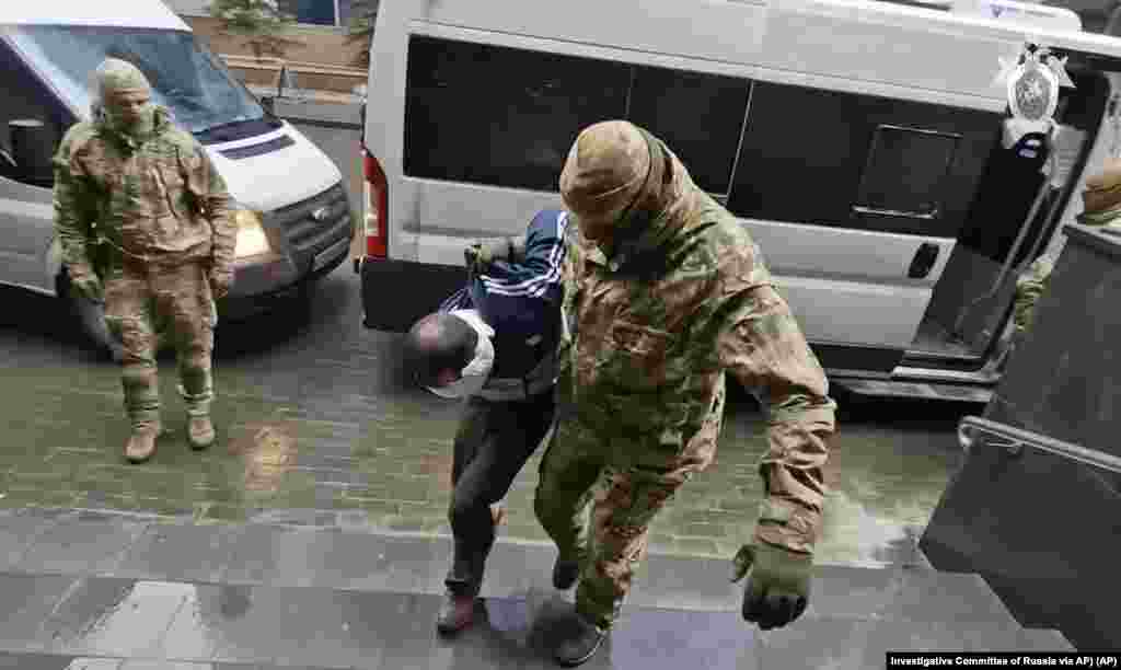 In this photo taken from video released by Investigative Committee of Russia on March 24, 2024, a suspect in the Crocus City Hall shooting on Friday is escorted to the Russian Investigative Committee headquarters in Moscow, Russia. 