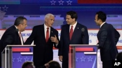 Former New Jersey Gov. Chris Christie, former Vice President Mike Pence, Florida Gov. Ron DeSantis and businessman Vivek Ramaswamy talk during break in a Republican presidential primary debate, Aug. 23, 2023, in Milwaukee.