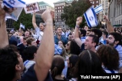 Para peserta aksi demo pro-Israel di Universitas Columbia, New York, menari sambil menyanyikan sebuah lagu saat protes, Kamis, 12 Oktober 2023. (AP/Yuki Iwamura)