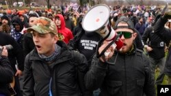 Anggota kelompok sayap kanan "Proud Boys", Zachary Rehl, kiri, dan Ethan Nordean, kanan, berjalan menuju Gedung Capitol di Washington, DC untuk mendukung Presiden Donald Trump pada hari terjadinya penyerbuan gedung Kongres AS, 6 Januari 2021.