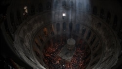 Orthodox Christians gather with lit candles around the Edicule, traditionally believed to be the burial site of Jesus Christ, during the annual Holy Fire ceremony in Jerusalem's Holy Sepulchre church, a day before Orthodox Easter, May 4, 2024. 