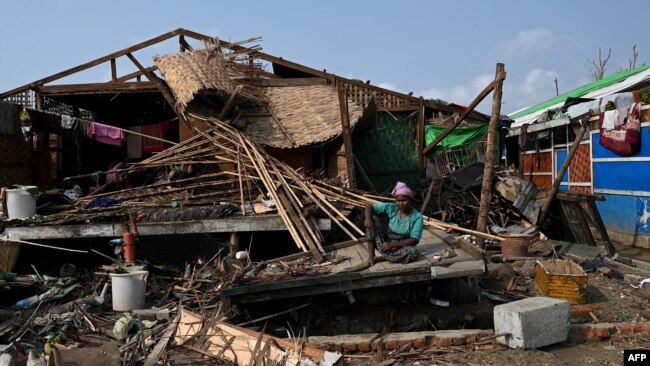 FILE - A Rohingya woman sits by her destroyed house at Ohn Taw Chay refugee camp in Sittwe on May 16, 2023, in the aftermath of Cyclone Mocha's landfall.
