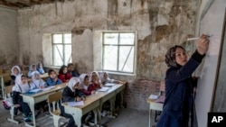 FILE - A teacher instructs young girls in Kabul, Afghanistan, March 25, 2023. The Taliban have prohibited girls from attending school beyond the sixth grade.