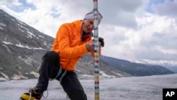 FILE - Matthias Huss, a Swiss Federal Institute of Technology glaciologist, checks the thickness of the Rhone Glacier near Goms, Switzerland, on June 16, 2023.