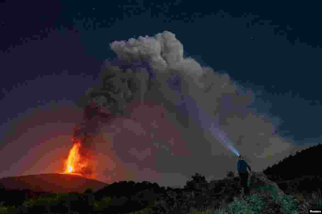 Seorang mengamati muntahan lava dan gumpalan asap vulkanik mengepul dari kawah Gunung Etna di Italia, gunung berapi paling aktif di benua Eropa. (Reuters)&nbsp;