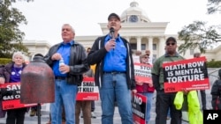 Former death row inmates who were exonerated, from left, Randall Padgent, Gary Drinkard and Ron Wright, were among the protestors gathered at Alabama's capitol, on Jan. 23, 2024, to ask the governor to stop the execution of Kenneth Eugene Smith. 
