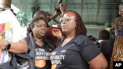 FILE - Human rights activists stand outside the Constitutional Court in Kampala, Uganda, April 3, 2024, as the court was giving its seal of approval to an anti-homosexuality law. Opponents filed an appeal against the law with the Supreme Court on July 11, 2024.