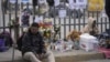 一名委内瑞拉移民坐在墨西哥移民中心为火灾死难者搭起的纪念坛旁。（2023年3月30日） 