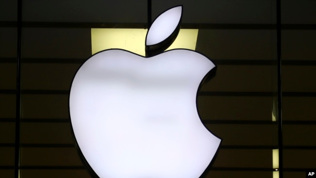 FILE - The Apple logo is illuminated at a store in the city center of Munich, Germany, Dec. 16, 2020. European Union fines Apple nearly $2 billion for unfairly favoring its own music streaming service over rivals.