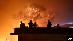 Vatrogasci se okupljaju u blizini požara u Tučepima, u Hrvatskoj, kasno u utorak, 30. jula 2024. (Foto: Ivo Ravlić, Cropiks preko AP)