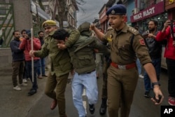 Police officers detain a member of Aam Admi Party, or Common Man's Party, during a protest against the arrest of their party leader Arvind Kejriwal, in Srinagar, Indian-administered Kashmir, March 22, 2024.
