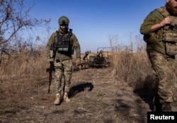 Ukrainian servicemen walk at a position near a front line, amid Russia's attack on Ukraine, in Donetsk region, Ukraine, Oct. 15, 2023.