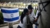 Members of Colombia's Israeli community erase antisemitic graffiti outside Israel's Embassy in Bogota, Colombia, Oct. 9, 2023, two days after Hamas fighters launched a deadly surprise attack against Israel.